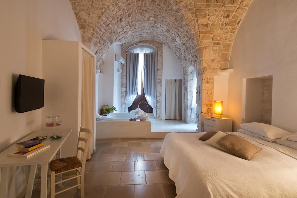 une chambre avec un lit et une salle de bain avec baignoire dans l'établissement Hotel Corte Altavilla, à Conversano