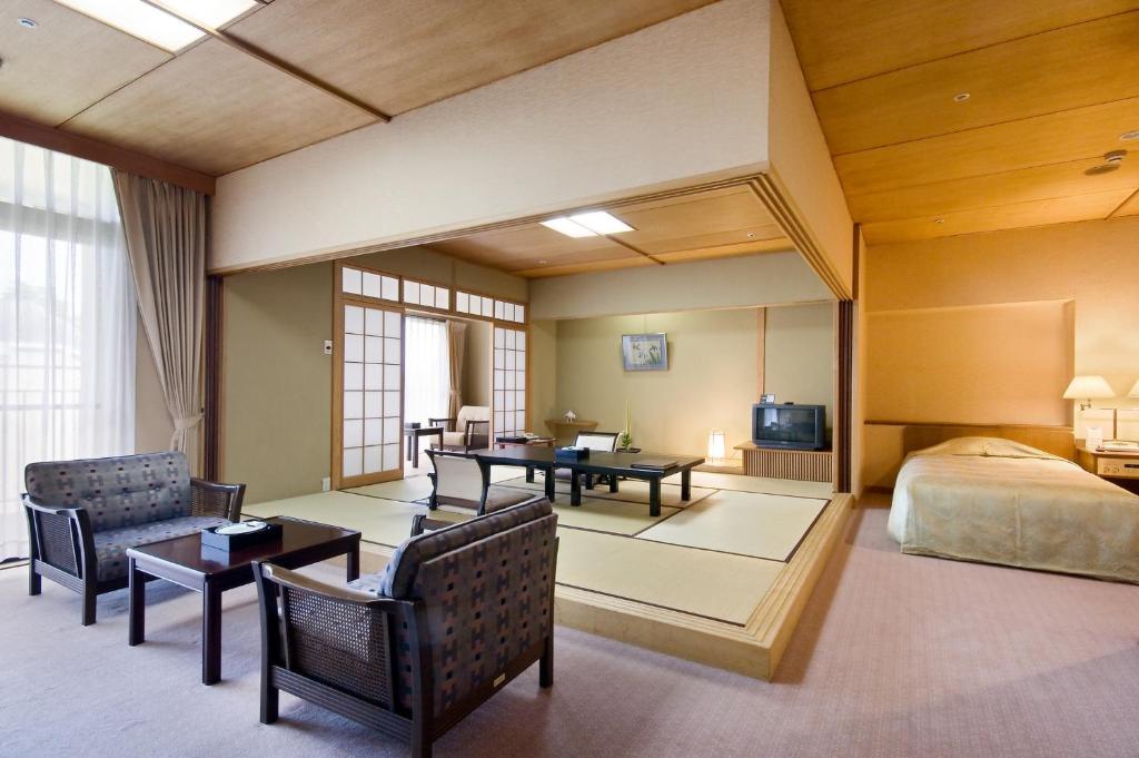 une chambre d'hôtel avec un lit et une chambre dans l'établissement Funaya, à Matsuyama