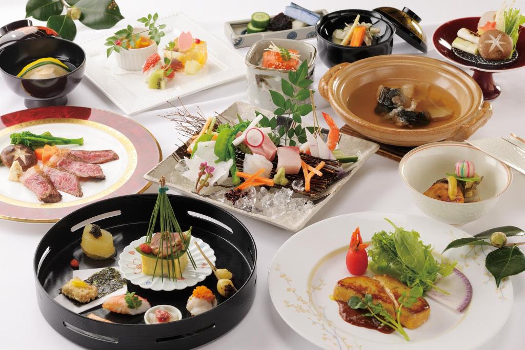 une table avec de nombreuses assiettes de nourriture dessus dans l'établissement Ryotei Hanayura, à Noboribetsu