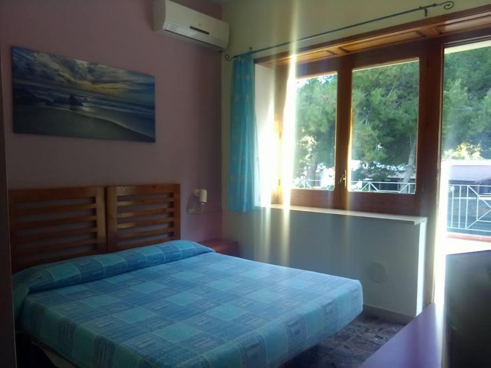 une chambre avec un lit avec une couette bleue et une fenêtre dans l'établissement Hotel Vela Velo Club Vieste, à Vieste 162 autres photos