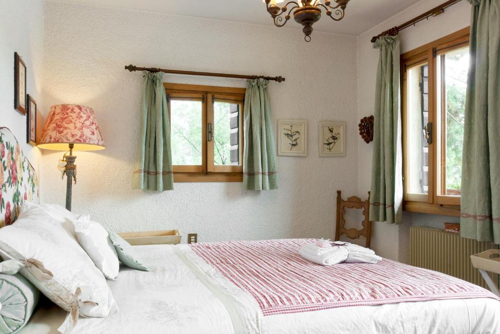 une chambre avec un lit et deux fenêtres dans l'établissement Asolo hills La Cimetta chic villa with pool, à Asolo