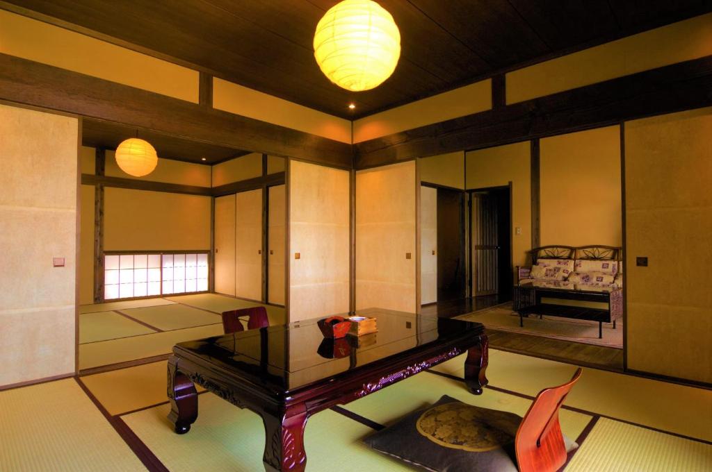 une chambre avec une table et une chambre avec un lit dans l'établissement Tsuki no Usagi, à Itō