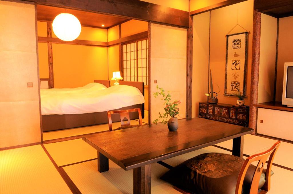 - une chambre avec un lit, une table et une table dans l'établissement Tsuki no Usagi, à Itō
