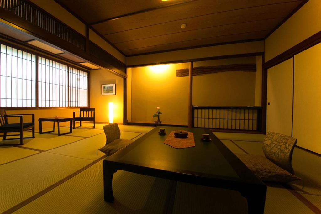 un salon avec une grande table et des chaises dans l'établissement Nansuikaku, à Miyawaka
