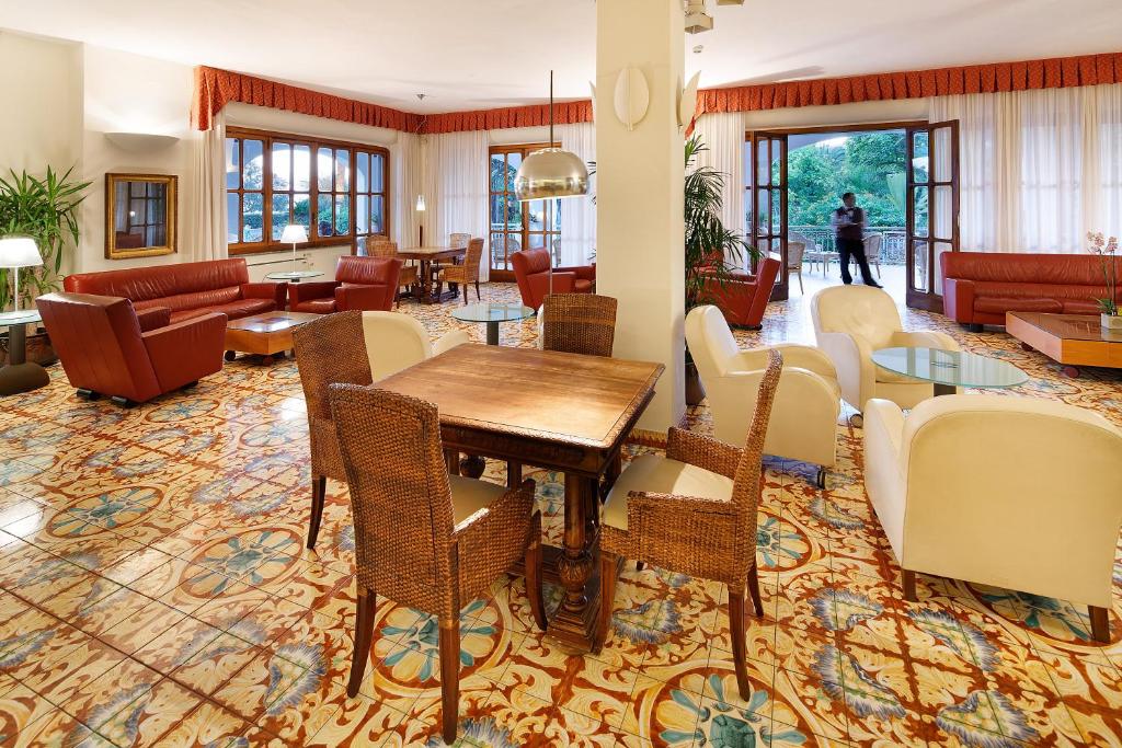 un salon avec une table et des chaises dans l'établissement Parco Smeraldo Appartamenti, à Ischia