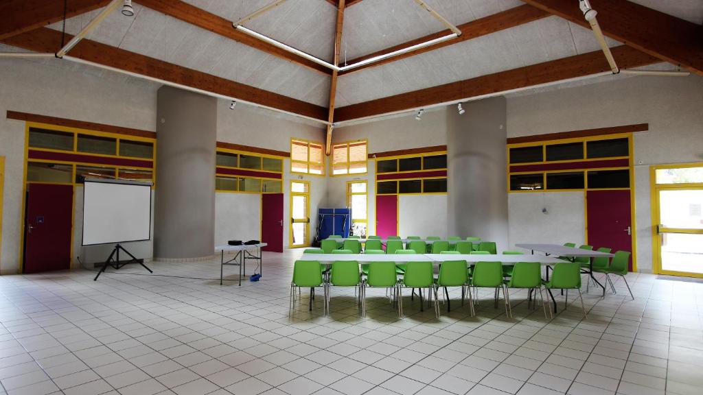 Cette grande chambre comprend des tables, des chaises et un tableau blanc. dans l'établissement Chanteduc, à Beaurières 34 autres photos