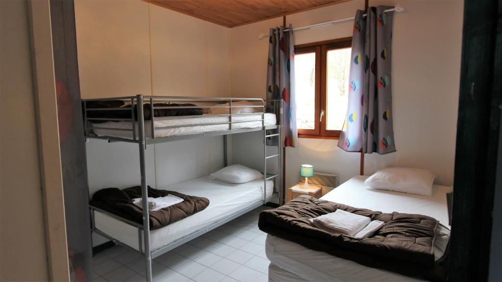 une chambre avec deux lits superposés et une fenêtre dans l'établissement Chanteduc, à Beaurières