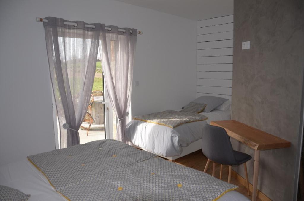 une chambre avec deux lits et une fenêtre dans l'établissement Gîte "La Grange" 5 personnes proche du Puy du Fou avec piscine, à Mortagne-sur-Sèvre
