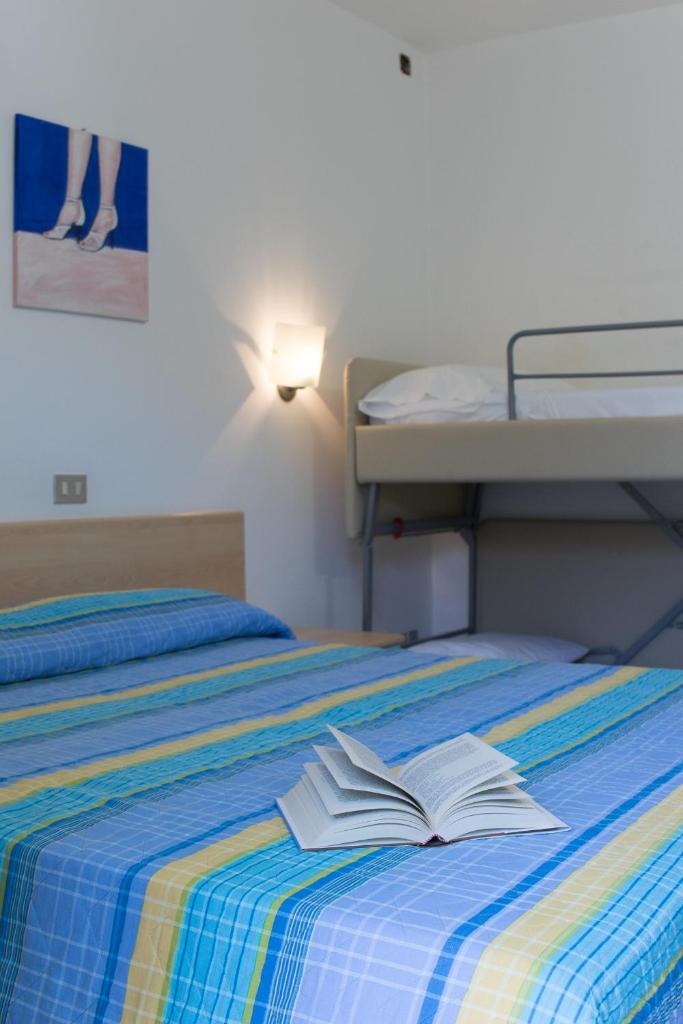 un lit avec un livre ouvert dessus dans l'établissement Hotel Elvia, à Lignano Sabbiadoro