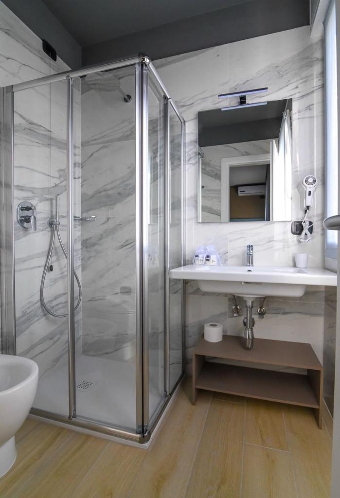 une salle de bain avec douche et lavabo dans l'établissement Hotel Ristorante Fortuna, à Cavallino-Treporti