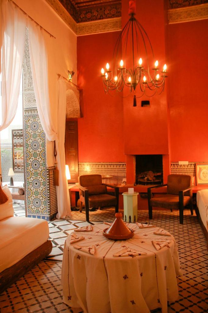 un salon avec un lit et un lustre dans l'établissement Riad Tizwa Fes, à Fès
