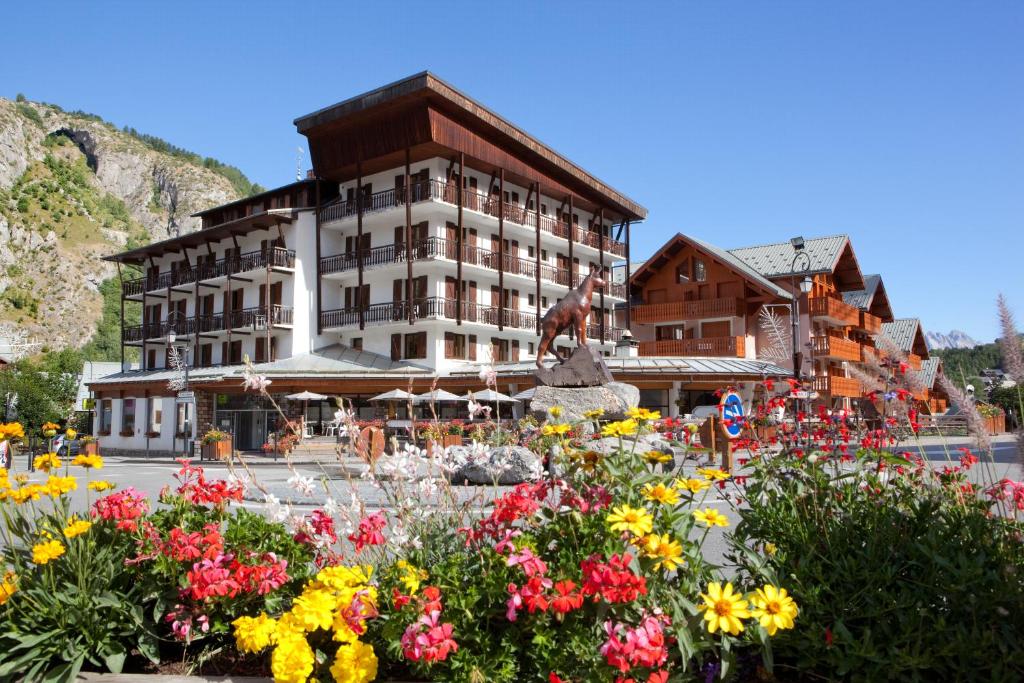 un grand bâtiment avec des fleurs devant lui dans l'établissement Grand Hotel de Valloire et du Galibier, à Valloire