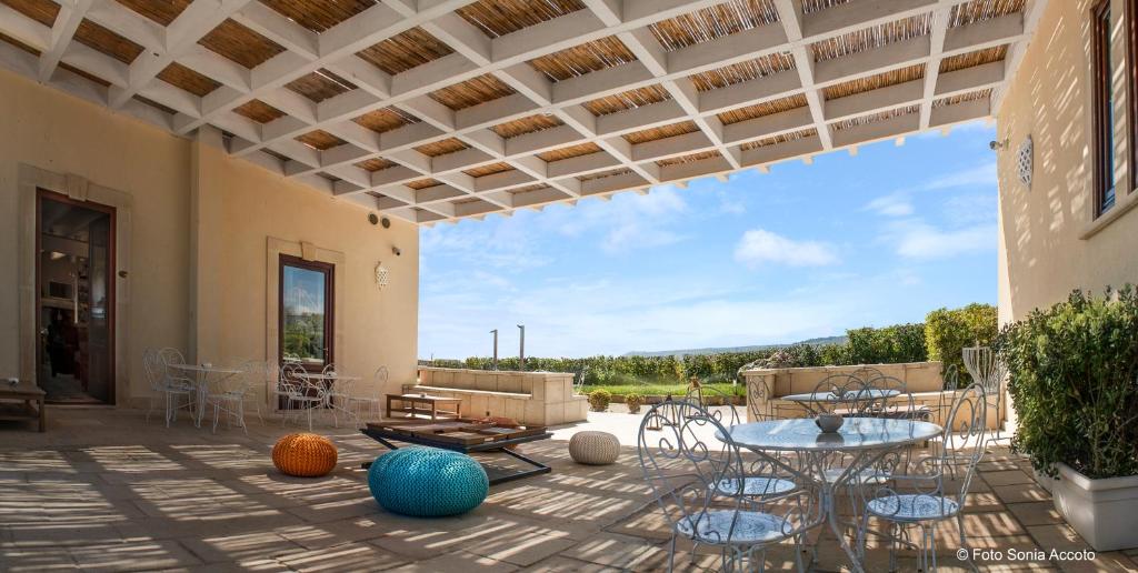 un patio avec une table et des chaises sur un patio dans l'établissement Palascìa Wellness Relais, à Otrante