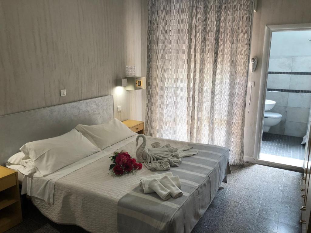 - une chambre dotée d'un lit avec un cygne et des fleurs dans l'établissement Hotel Monti, à Riccione