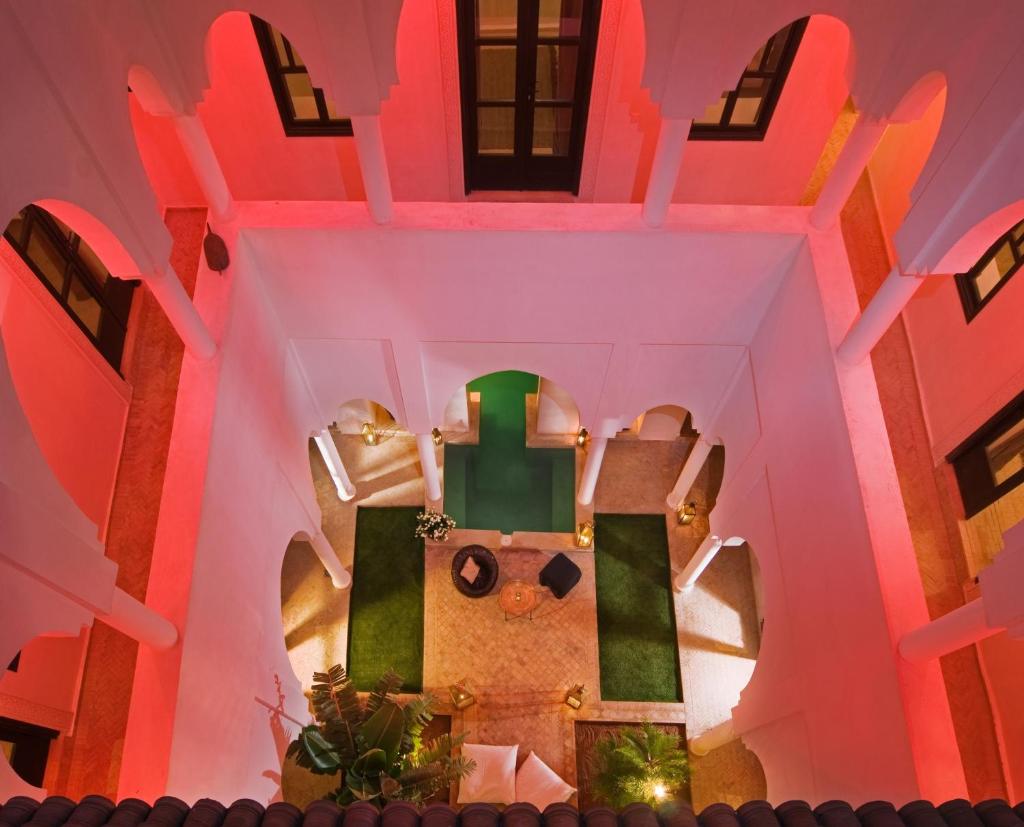 - une vue sur l'intérieur d'une chambre avec un éclairage rose et vert dans l'établissement Riad Capaldi, à Marrakech