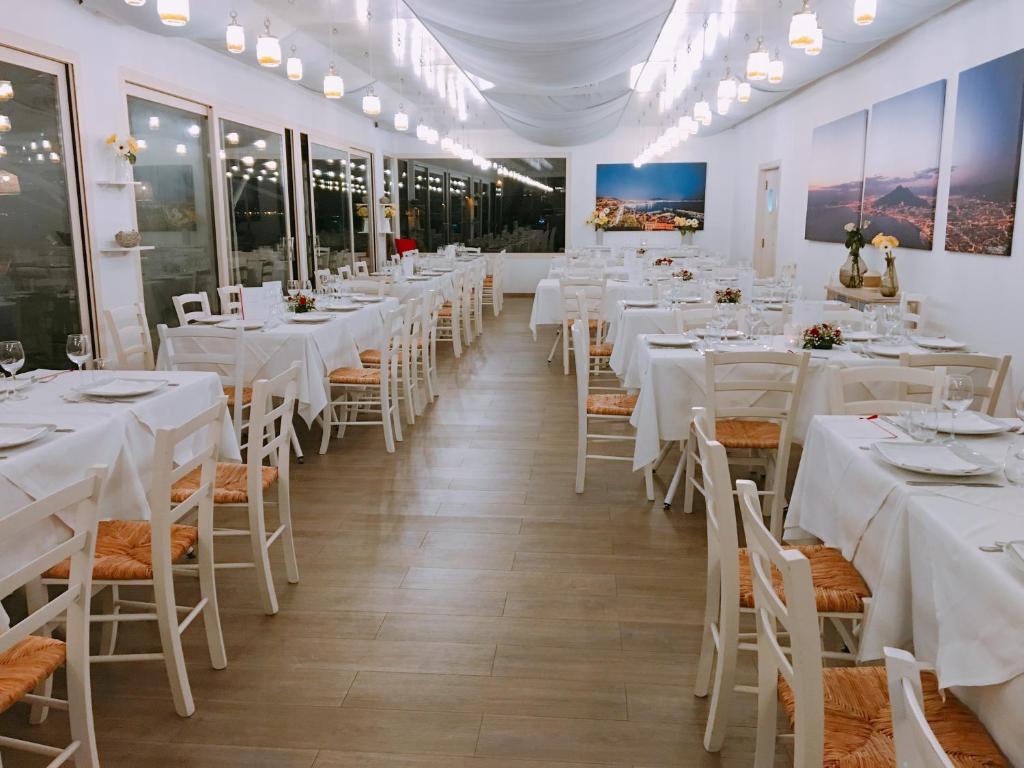 Cette chambre est dotée de tables, de chaises et de linge de maison blanc. dans l'établissement Puntaquattroventi, à Ercolano