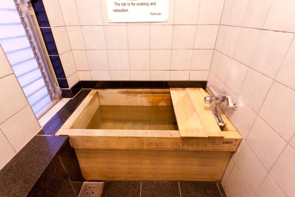 La salle de bains est pourvue d'une baignoire et d'un lavabo. dans l'établissement Kimi Ryokan, à Tokyo