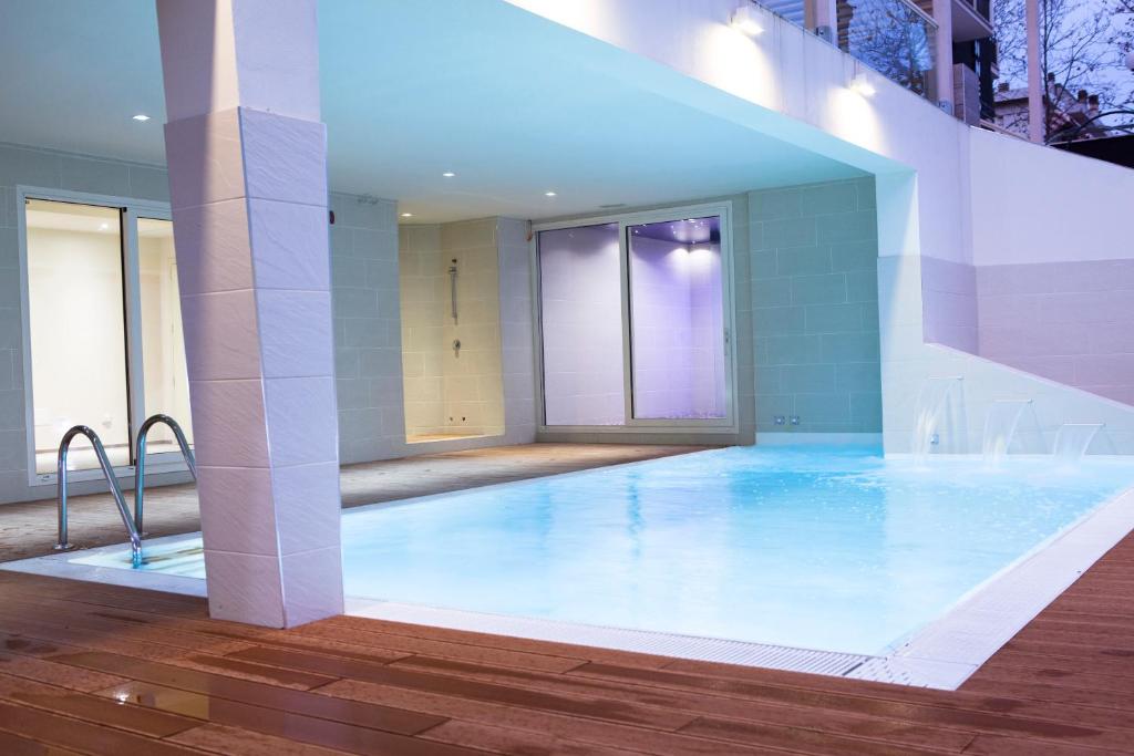 une grande piscine au milieu d'un bâtiment dans l'établissement L'Hotel, à Rimini