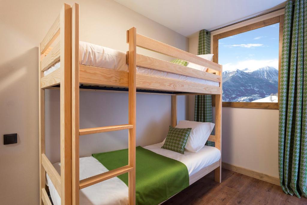 - une chambre avec des lits superposés, une fenêtre et des montagnes dans l'établissement Résidence Club MMV L'Altaviva, à Tignes