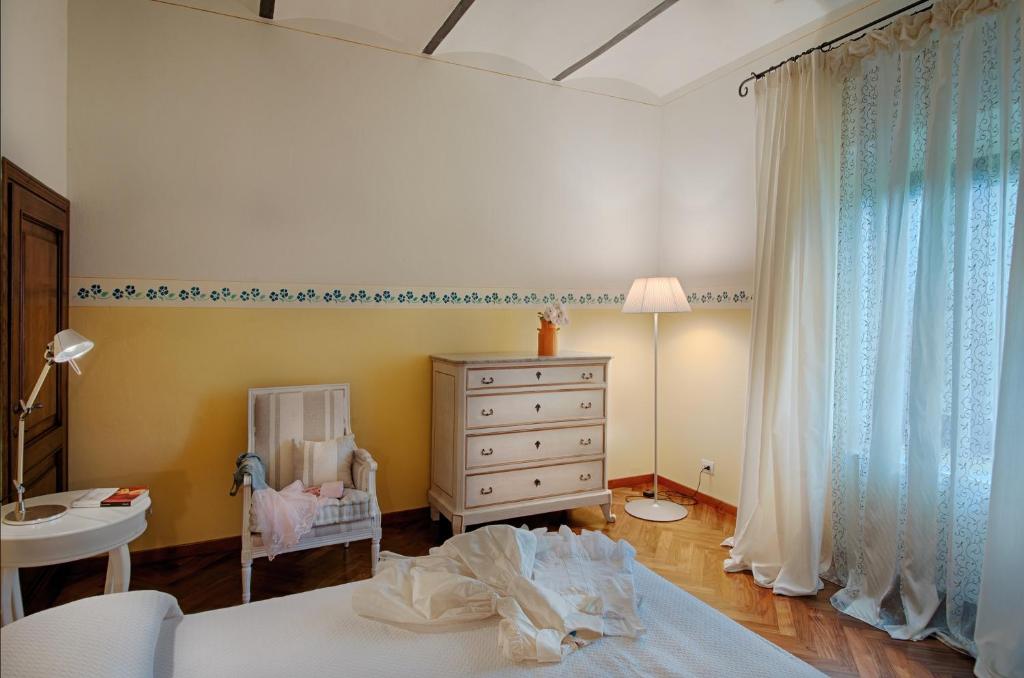 - une chambre avec un lit, une commode et un lit bébé dans l'établissement Tenuta Cambiano by PosarelliVillas, à Castelfiorentino
