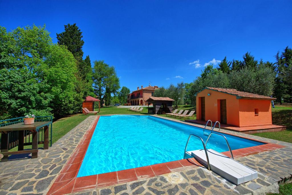 une piscine dans une cour avec une maison dans l'établissement Villa Mario by PosarelliVillas, à Lucignano