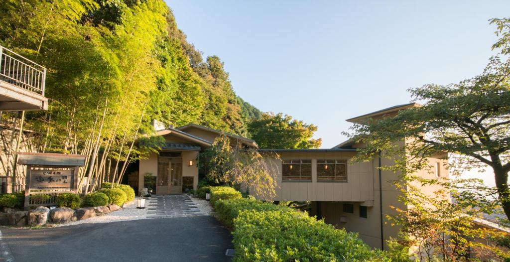 une maison avec une passerelle menant à celle-ci dans l'établissement Takimotokan Yuki No Sato, à Yoro