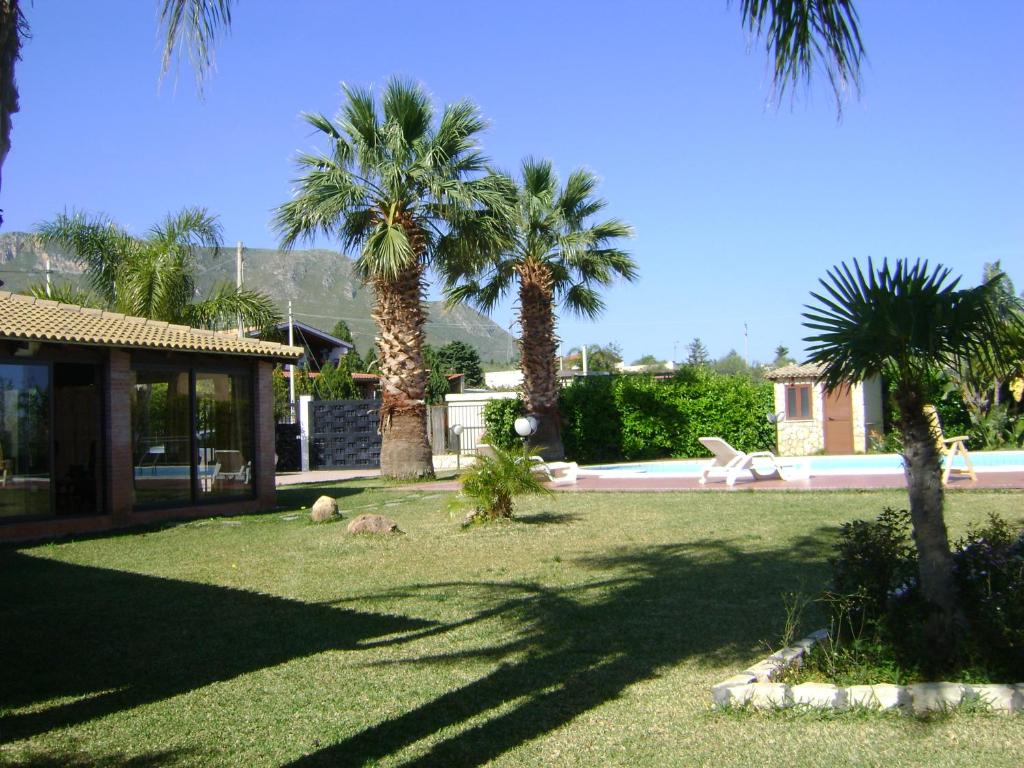 une cour avec des palmiers et une maison dans l'établissement Villa Cocus, à Altavilla Milicia