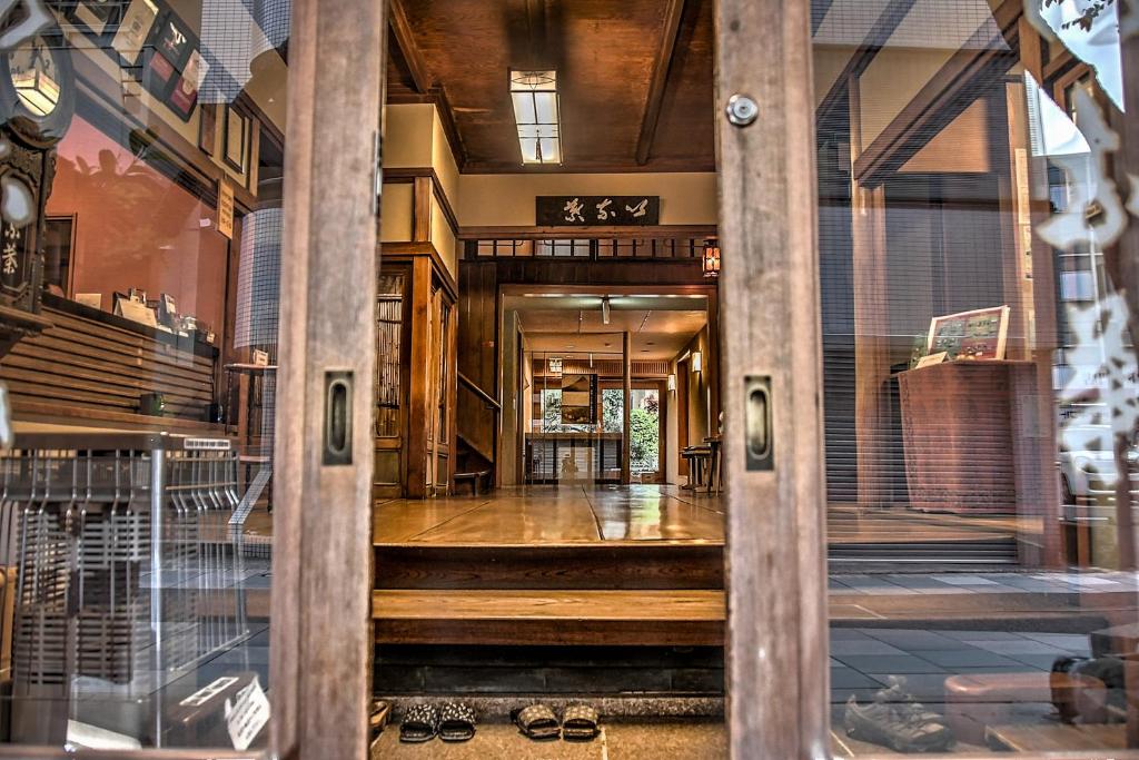 un accès à un bâtiment avec une porte en verre dans l'établissement K's House Ito Onsen - Historical Ryokan Hostel, à Itō