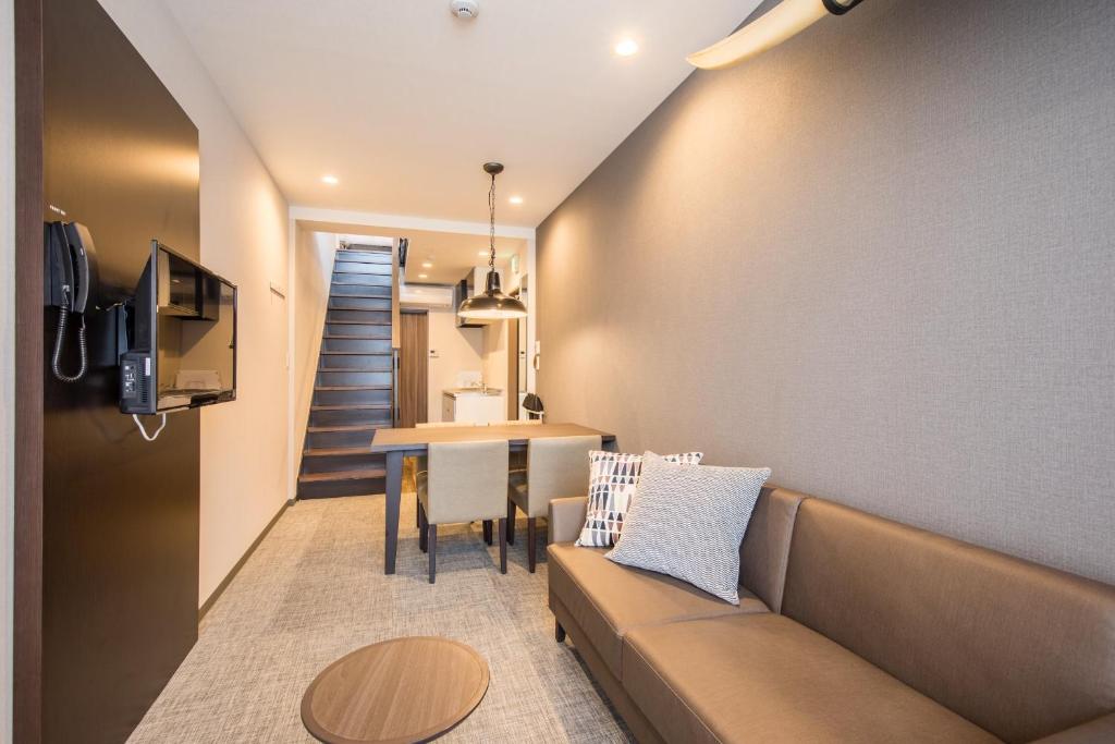 un salon avec un canapé et une table dans l'établissement HOTEL R9 Kujukuri "ex Casual Resort COFF Ichinomiya", à Ichinomiya