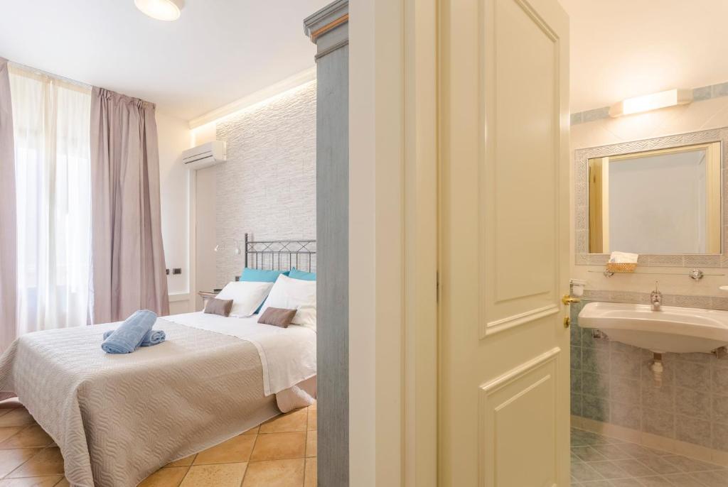 une chambre avec un lit et une salle de bain avec un lavabo dans l'établissement Hotel Trinacria, à San Vito Lo Capo