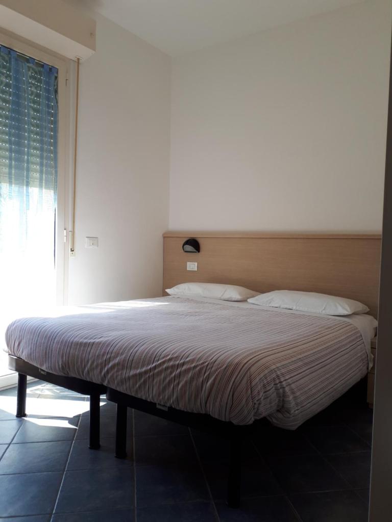 un lit dans une chambre avec une grande fenêtre dans l'établissement Residence Désirée, à Rimini