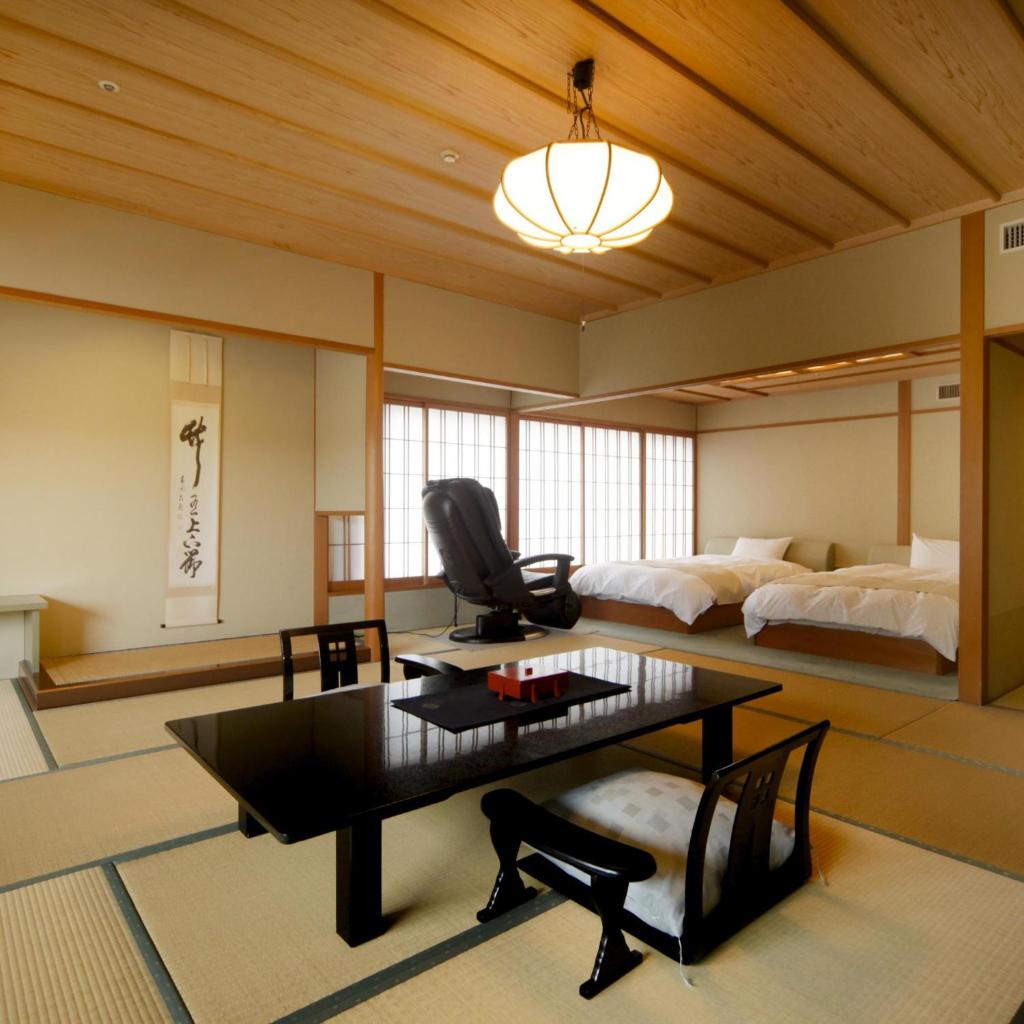 un salon avec une table et un lit dans l'établissement Kotohira Onsen Kotosankaku, à Kotohira