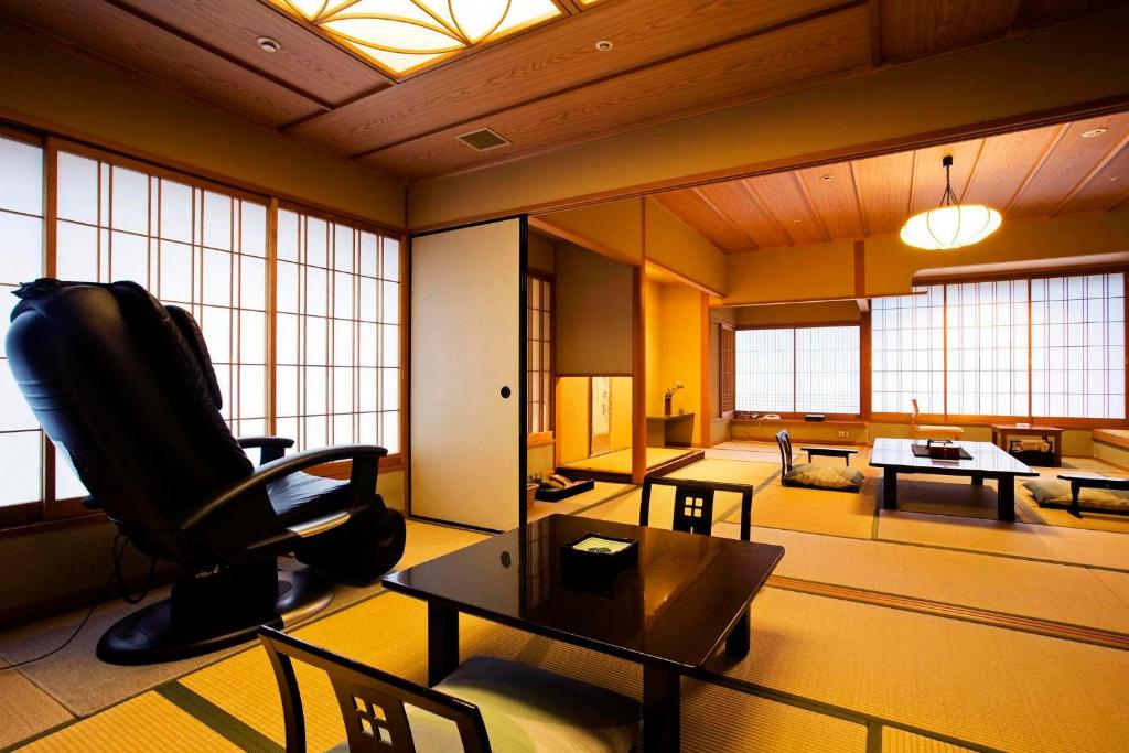 un salon avec un canapé, une table et des chaises dans l'établissement Kotohira Onsen Kotosankaku, à Kotohira