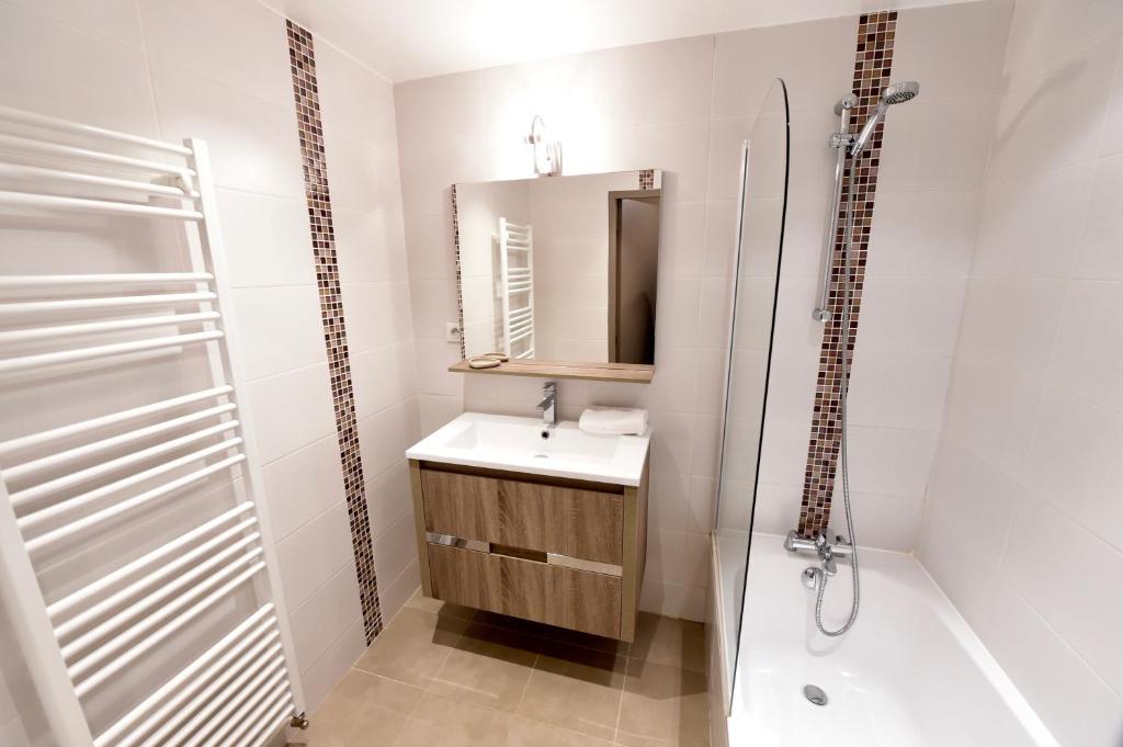 une salle de bain avec un lavabo, une douche et un miroir dans l'établissement A21 Roc de Péclet, à Val Thorens