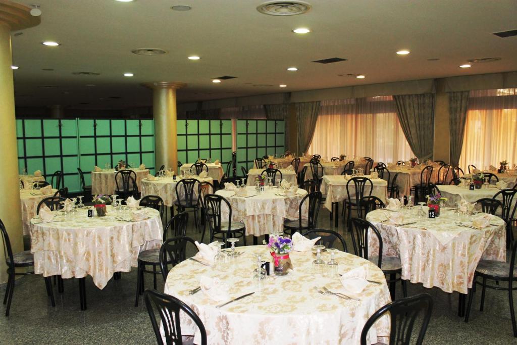 - une salle de banquet avec des tables, des chaises et du linge de maison blanc dans l'établissement Hotel A' CAPANNA, à Diamante