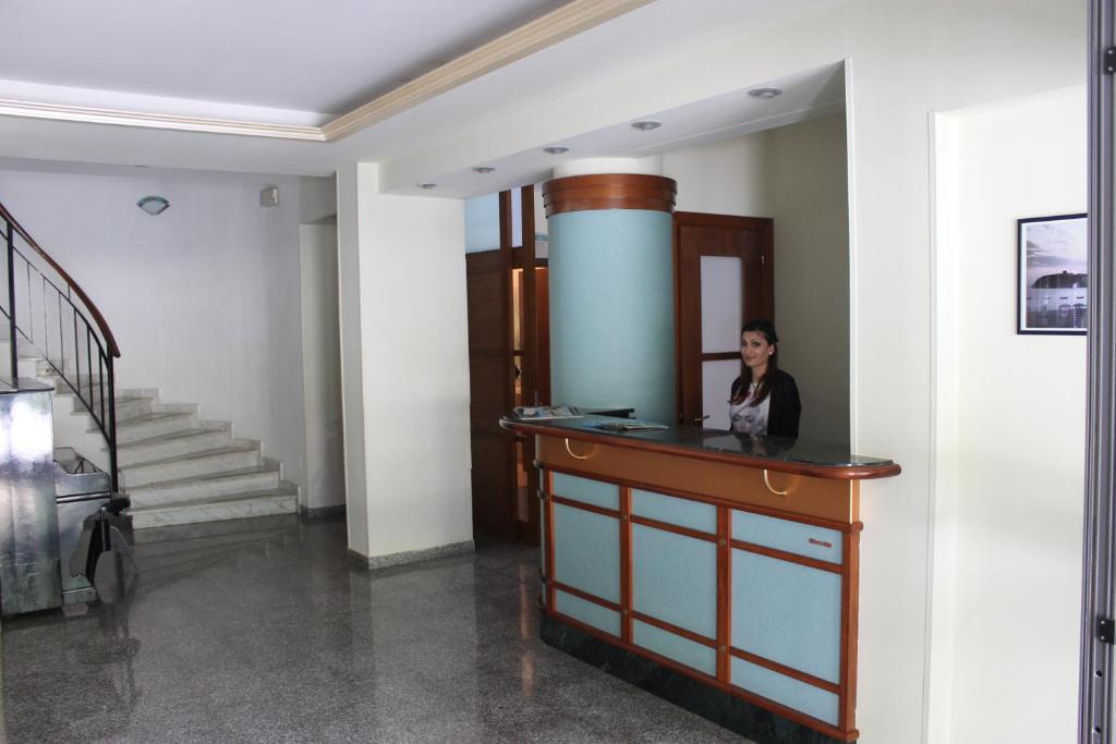 une femme assise à un comptoir dans une pièce dans l'établissement Hotel A' CAPANNA, à Diamante