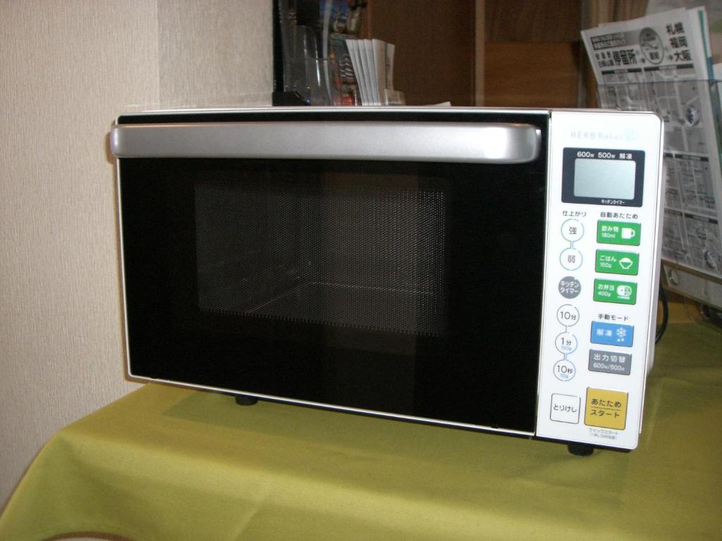 un four micro-ondes installé au-dessus d'une table verte dans l'établissement Nagomi-tei, à Hakuba