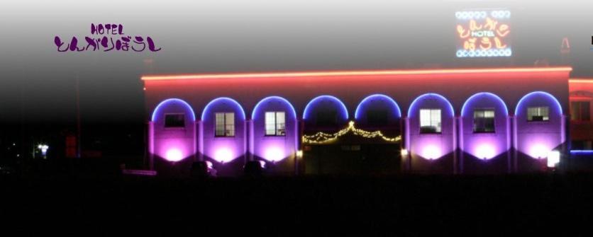 Un bâtiment avec des lumières violettes sur son côté dans l'établissement Tongariboshi (Adult Only), à Sakaide