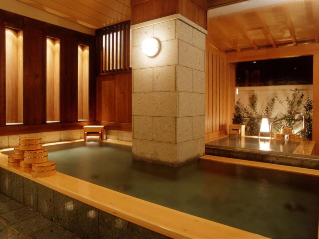 - une piscine d'eau avec pilier dans une chambre dans l'établissement Atami Onsen Sakuraya Ryokan, à Atami
