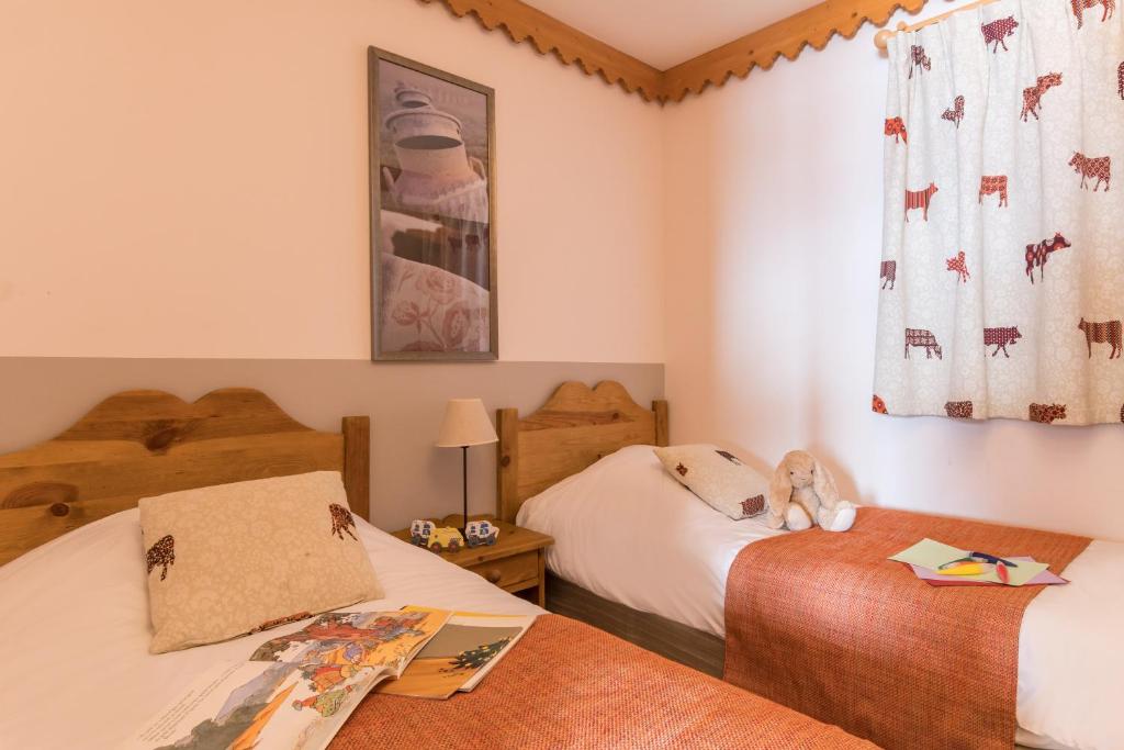 une chambre avec deux lits et une fenêtre dans l'établissement Résidence Pierre & Vacances Premium Les Hauts Bois, à Aime La Plagne
