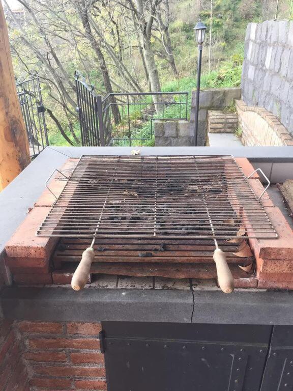 un grill au charbon de bois avec pinces au-dessus dans l'établissement Villa Maria, à Zafferana Etnea