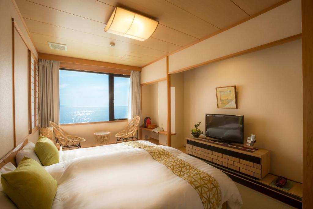 une chambre d'hôtel avec un lit et une télévision dans l'établissement Jukaitei, à Kyōtango