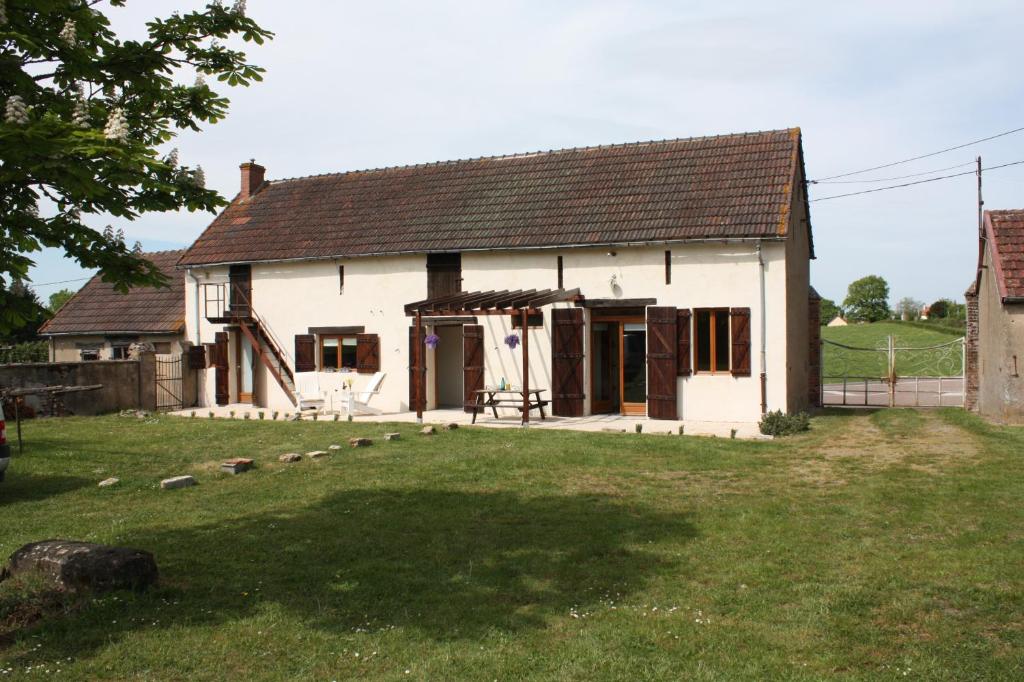 une maison blanche avec une grande cour devant elle dans l'établissement Gîte Chevannes, à Fours
