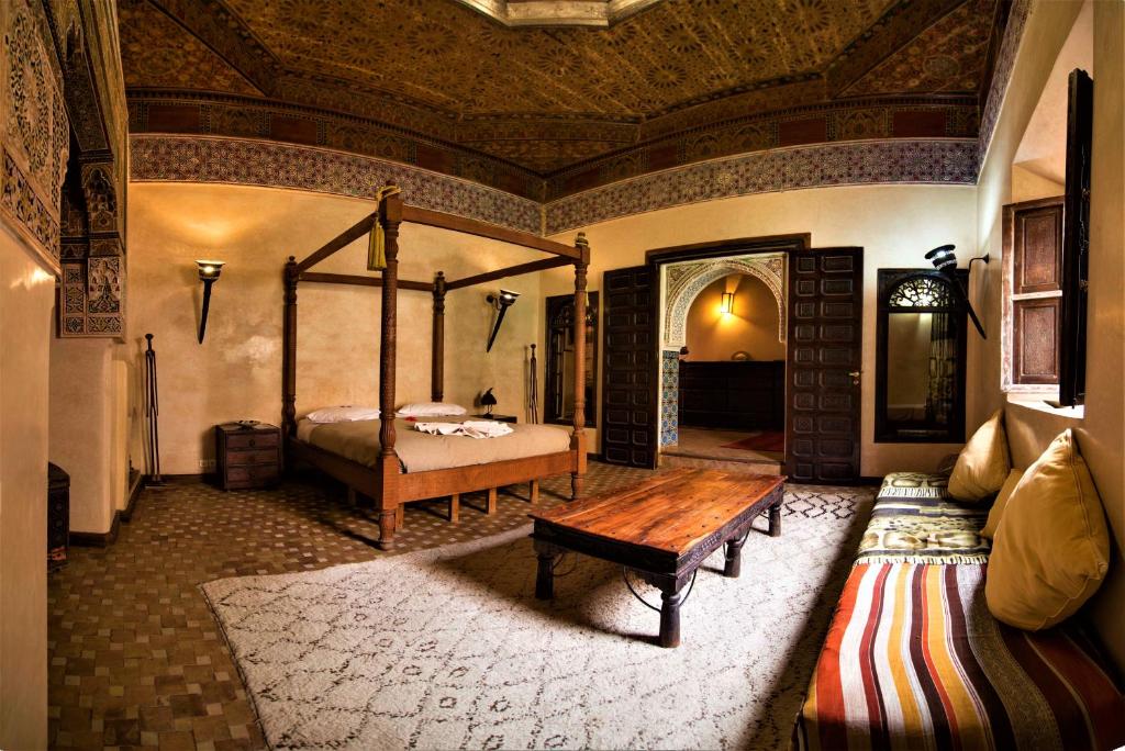 une chambre avec un lit et une table en bois dans l'établissement Riad Bamileke, à Marrakech