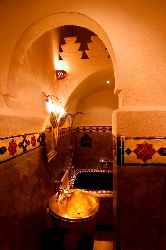 La salle de bains est pourvue d'un lavabo et d'une porte voûtée. dans l'établissement Riad Noga, à Marrakech