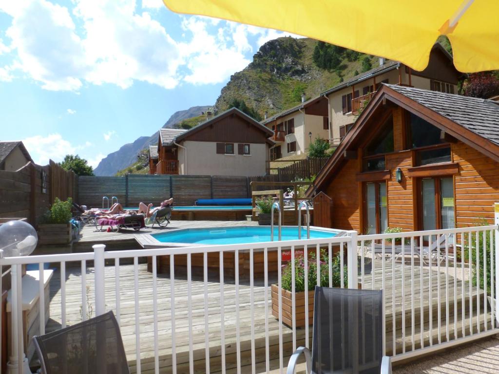 une cour arrière avec une piscine et une maison dans l'établissement Locations Cosy - Village Piéton avec Vue Glaciers - chez Philippe, à La Grave