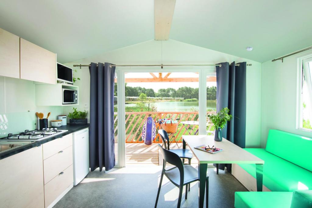 une cuisine et une salle à manger avec une table et des chaises dans l'établissement Paradis Des Dombes, à Sandrans