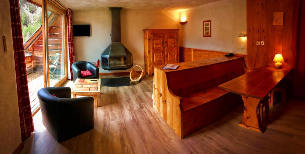 - un salon avec un lit en bois et une cheminée dans l'établissement Hôtel & Spa La Ferme de l'Izoard, à Arvieux
