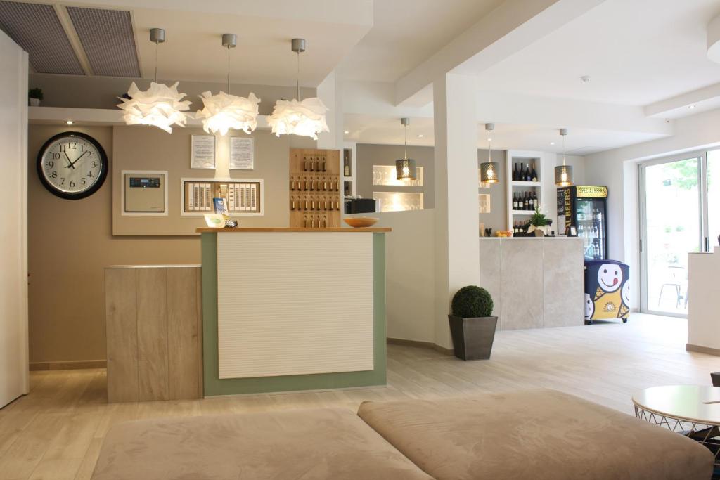 une salle avec un comptoir et une horloge sur le mur dans l'établissement Hotel Helga, à Caorle