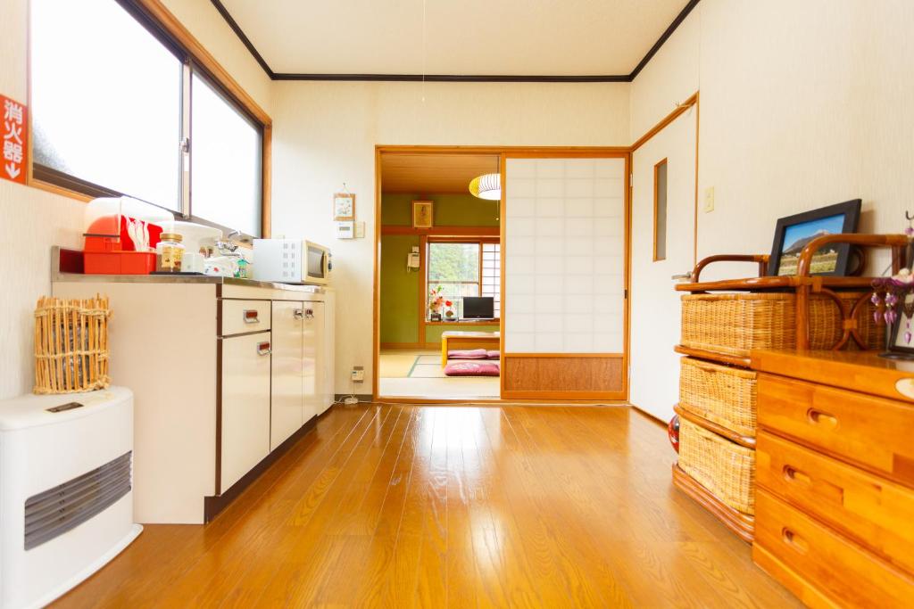 Il comprend une cuisine dotée de parquet et d'un réfrigérateur. dans l'établissement Yufuin Inakamura Inakaso, à Yufu